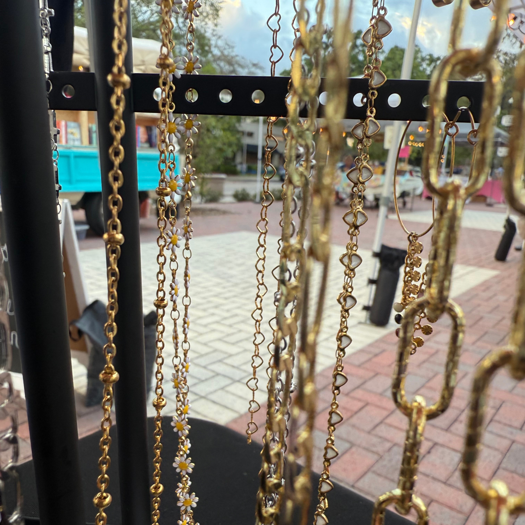 Gold permanent jewelry chains displayed in daylight