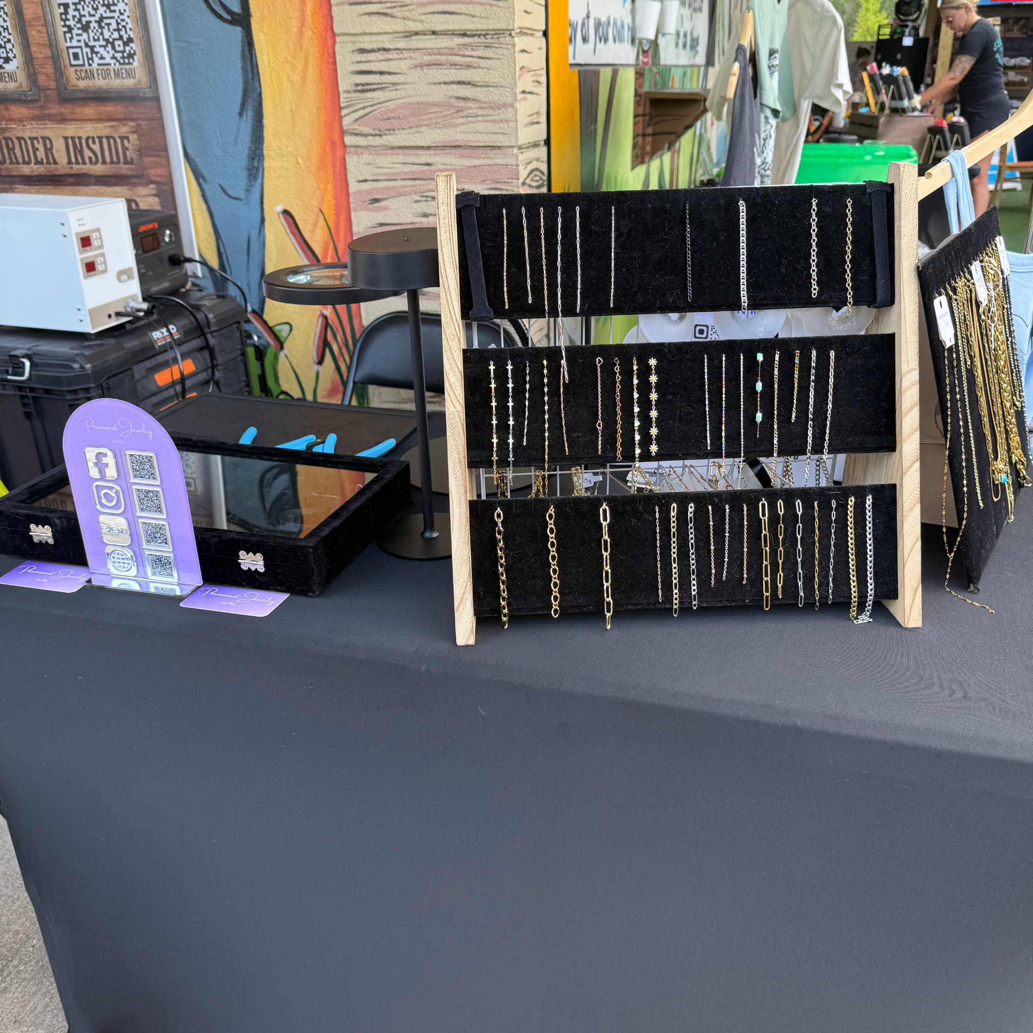 Permanent jewelry chain display at a pop-up event